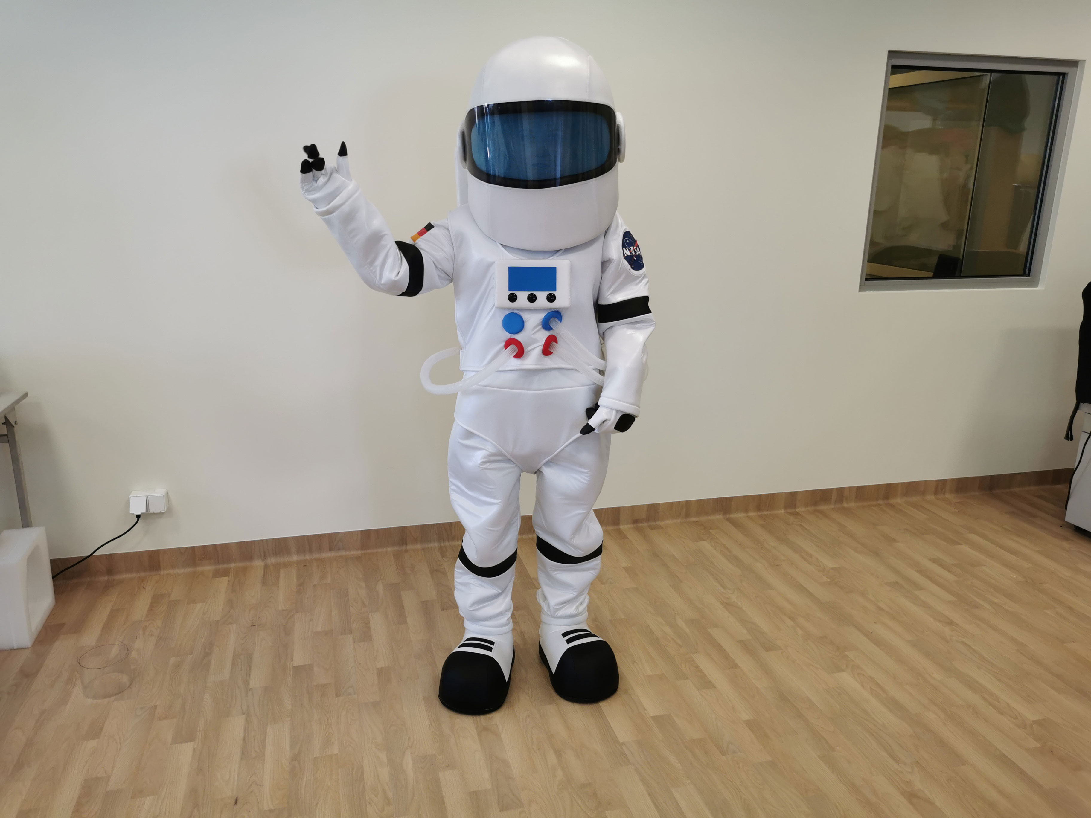 Na fotografii widniej kostium reklamowy inspirowany wyglądem skafandra kosmicznego pozujący do zdjęcia w siedzibie firmy Elabika